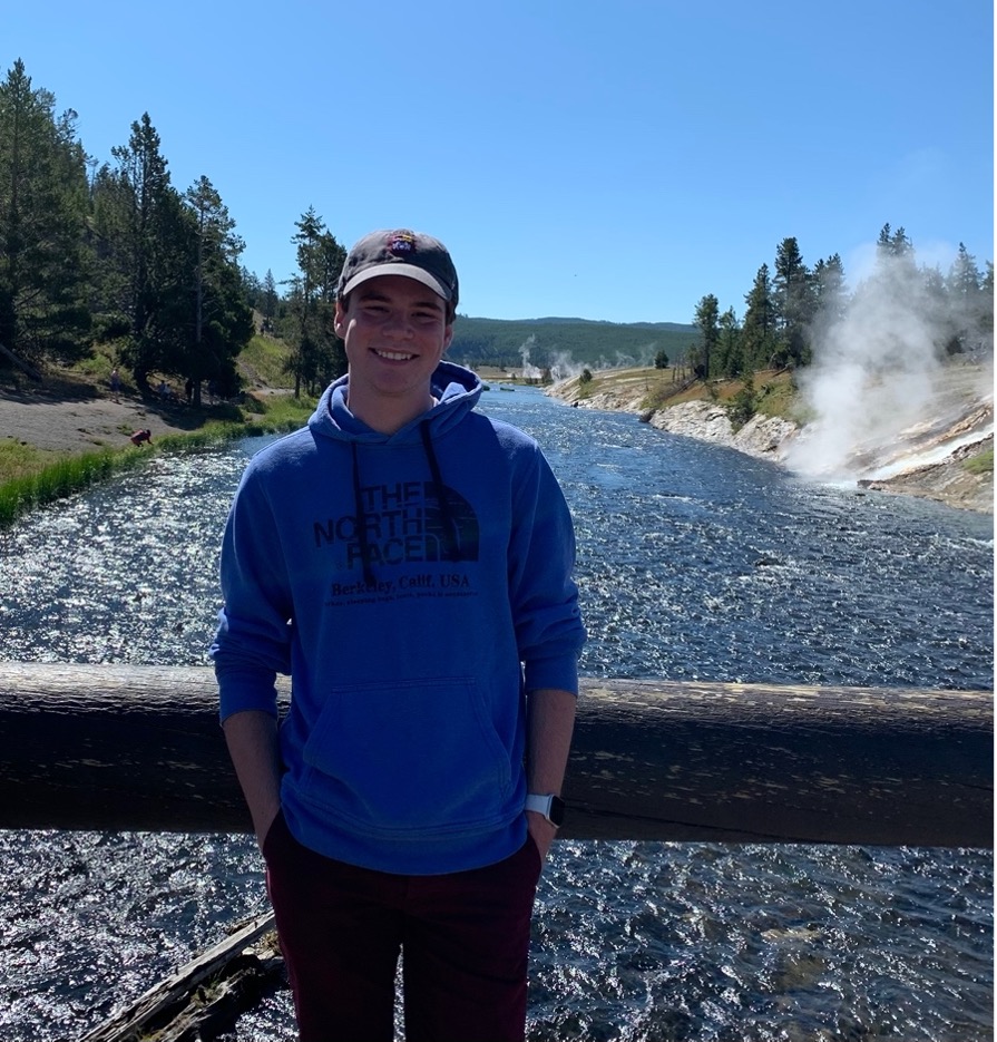 Image of Brennan McDonald standing on a bridge over a river